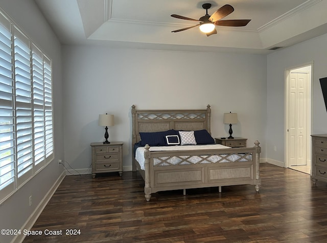 bedroom with a raised ceiling, crown molding, and dark hardwood / wood-style floors