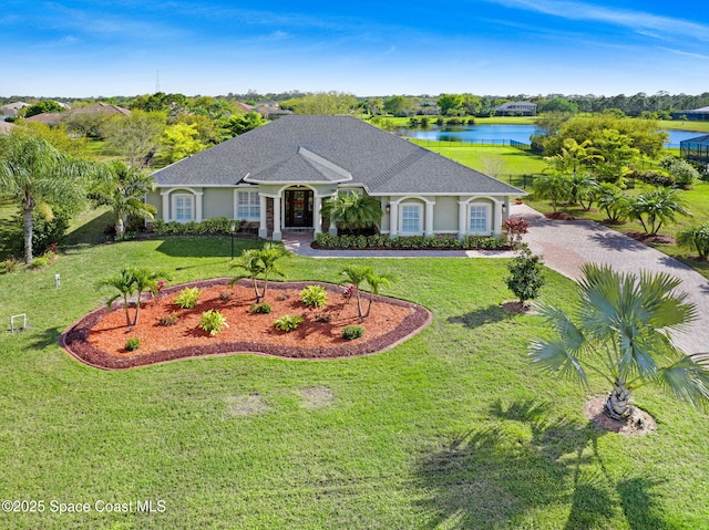 view of front of home with driveway, a front lawn, and a water view