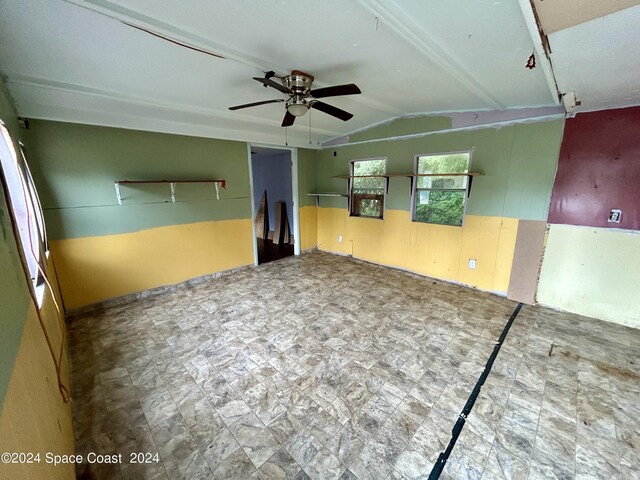 empty room featuring ceiling fan and vaulted ceiling