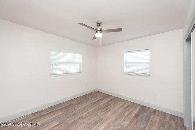 empty room featuring light hardwood / wood-style flooring, a healthy amount of sunlight, and ceiling fan