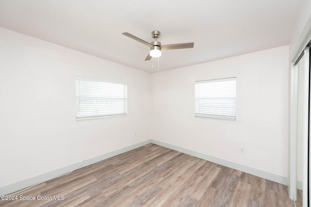 spare room with a wealth of natural light, light hardwood / wood-style floors, and ceiling fan