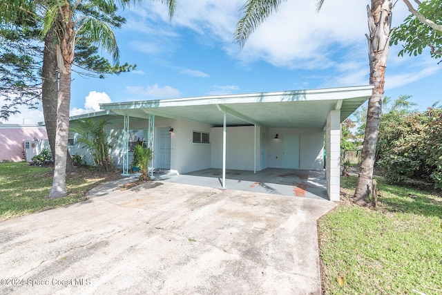 view of front of house with a carport and a front yard