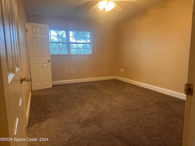 carpeted spare room with a textured ceiling and ceiling fan