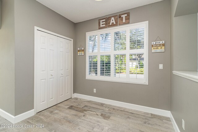 unfurnished bedroom with light hardwood / wood-style floors and a closet