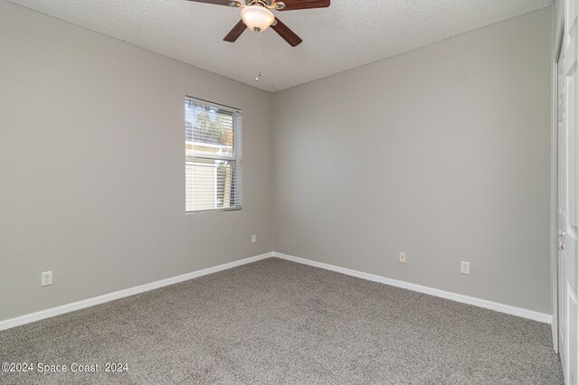 carpeted spare room with ceiling fan and a textured ceiling