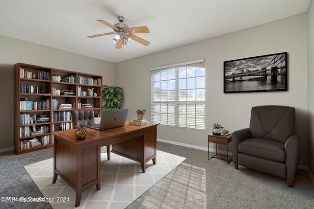 carpeted office space with ceiling fan