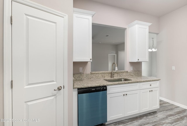 kitchen featuring stainless steel dishwasher, white cabinets, light stone counters, and sink