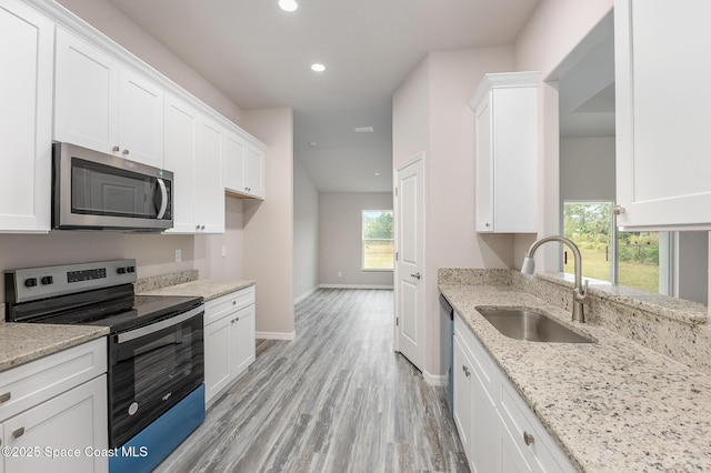 kitchen with appliances with stainless steel finishes, sink, and white cabinetry