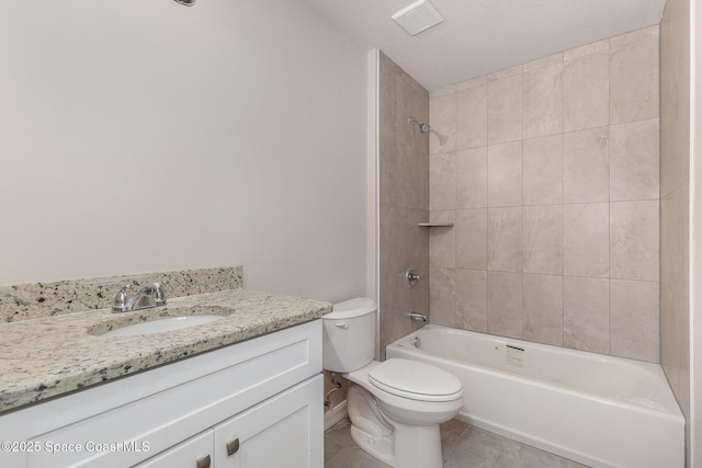 full bathroom featuring toilet, a textured ceiling, tiled shower / bath, and vanity