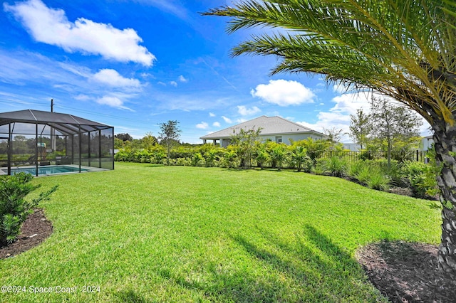 view of yard featuring a fenced in pool and a lanai