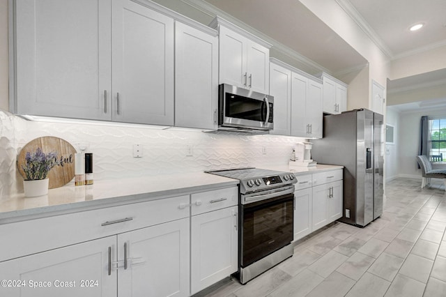 kitchen featuring ornamental molding, stainless steel appliances, white cabinetry, and tasteful backsplash