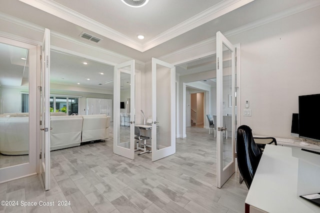 office with light hardwood / wood-style floors, french doors, and crown molding