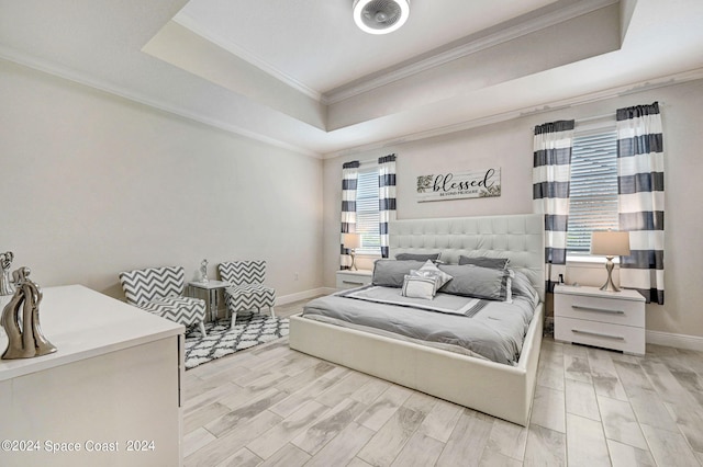 bedroom featuring light hardwood / wood-style flooring, multiple windows, a raised ceiling, and crown molding