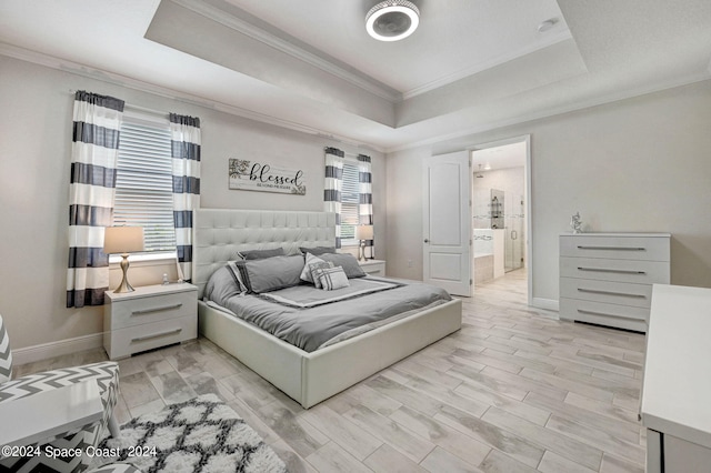 bedroom with a raised ceiling, connected bathroom, crown molding, and light hardwood / wood-style flooring