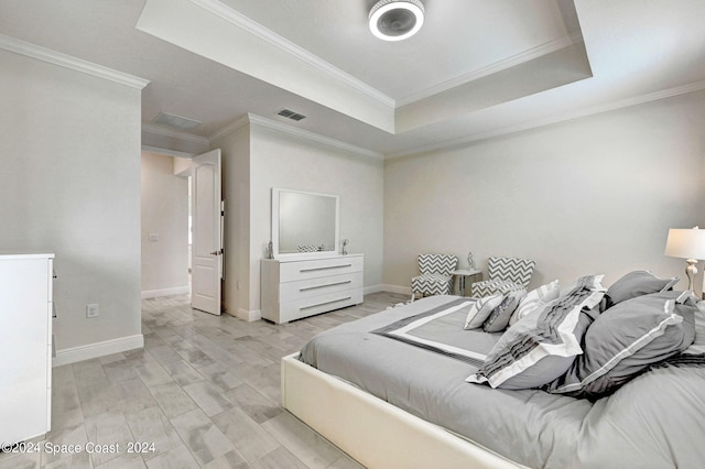 bedroom featuring light wood-type flooring, crown molding, and a tray ceiling