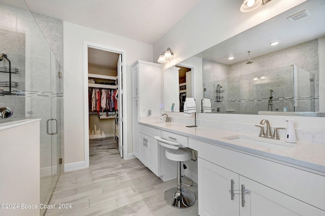 bathroom featuring walk in shower and vanity