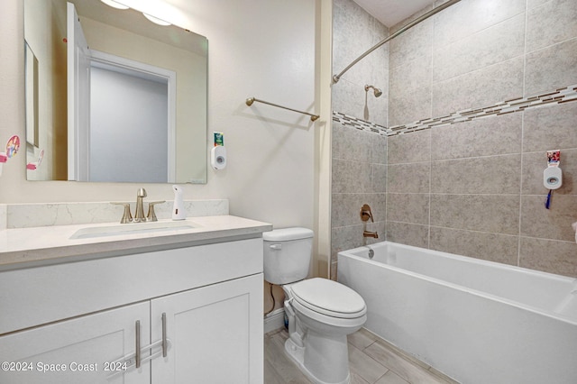 full bathroom featuring hardwood / wood-style floors, vanity, tiled shower / bath combo, and toilet