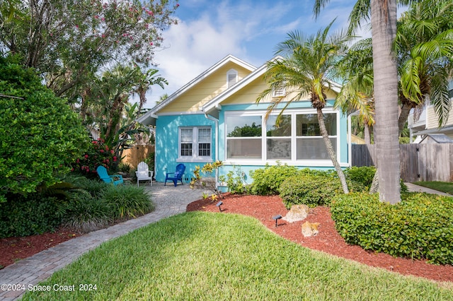 bungalow-style home featuring a front yard and a sunroom