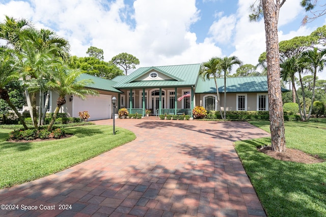 view of front of house with a garage, a front lawn, and covered porch