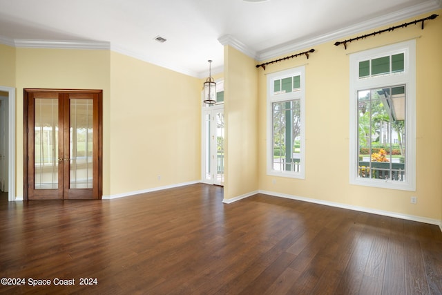 spare room with ornamental molding, dark hardwood / wood-style floors, french doors, and a wealth of natural light