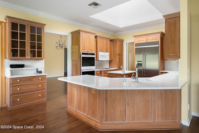 kitchen featuring built in refrigerator, dark hardwood / wood-style floors, kitchen peninsula, and crown molding