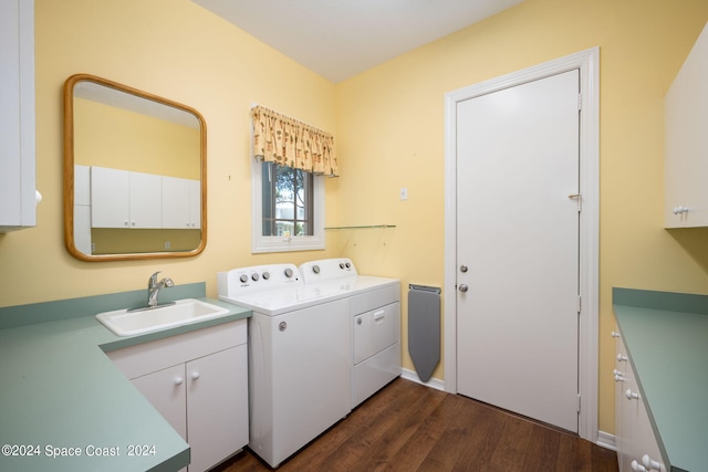 washroom featuring dark hardwood / wood-style flooring, cabinets, sink, and washer and dryer