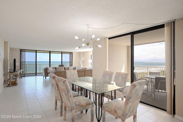 tiled dining area featuring a water view, floor to ceiling windows, and plenty of natural light