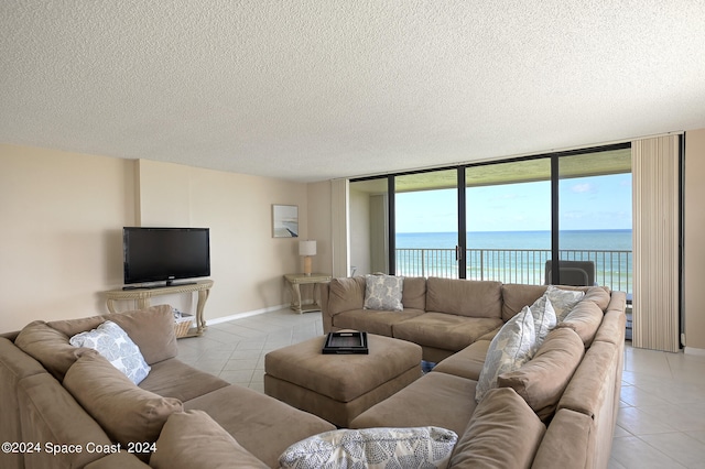 living room with expansive windows, a textured ceiling, and light tile patterned floors