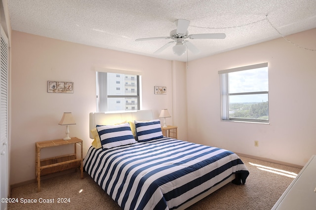 carpeted bedroom with a textured ceiling, ceiling fan, and a closet