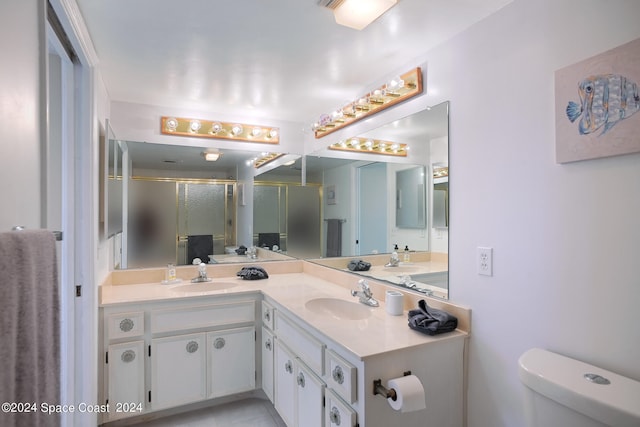 bathroom with vanity, toilet, and a shower with shower door