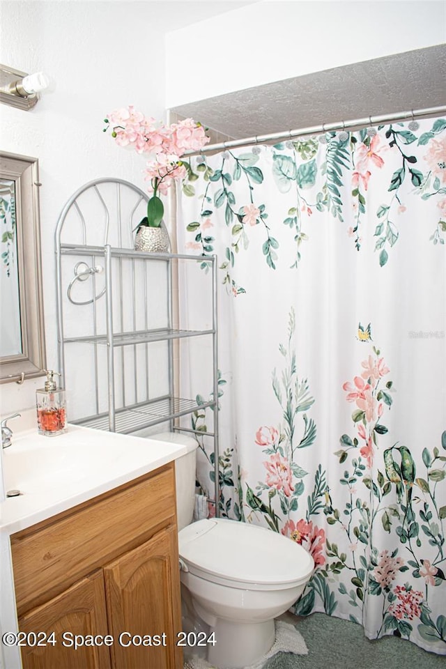 bathroom with vanity, toilet, and curtained shower