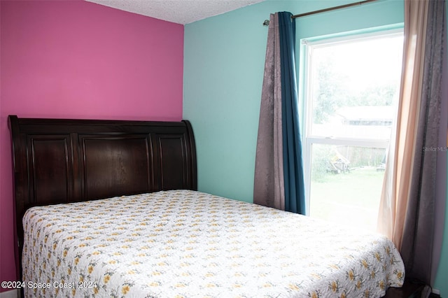 bedroom featuring multiple windows and a textured ceiling