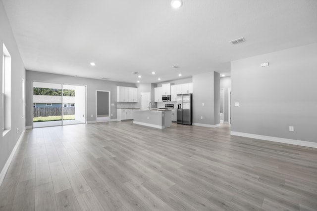 unfurnished living room with light wood-type flooring and sink