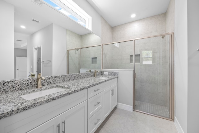 bathroom featuring tile patterned flooring, vanity, and an enclosed shower