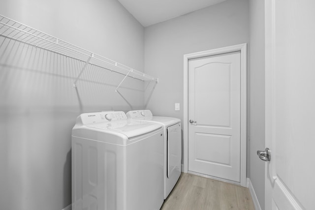 laundry area with light wood-type flooring and washing machine and dryer