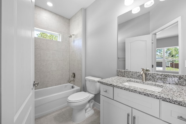 full bathroom with tiled shower / bath combo, vanity, toilet, and tile patterned floors