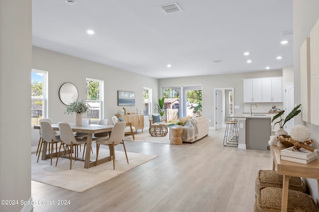 dining room with sink and light hardwood / wood-style flooring