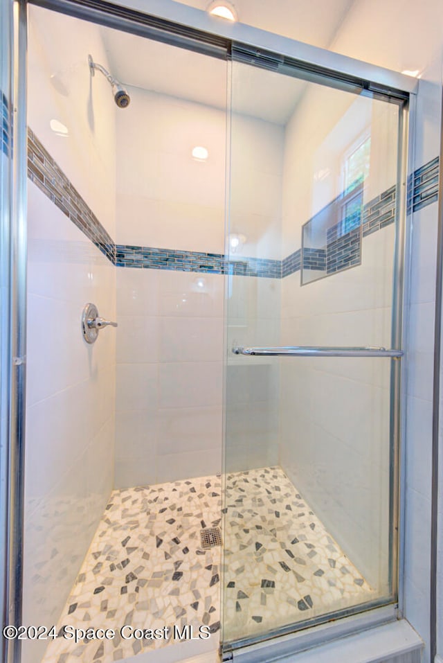 bathroom with a shower with door