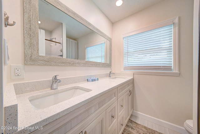 bathroom featuring curtained shower, vanity, and toilet