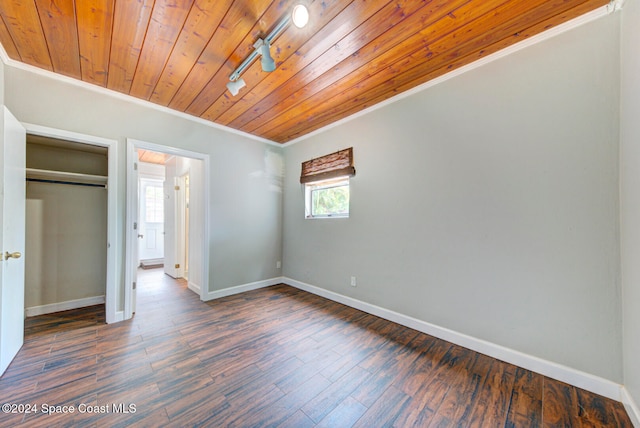 unfurnished bedroom featuring dark hardwood / wood-style flooring, crown molding, wood ceiling, and a closet