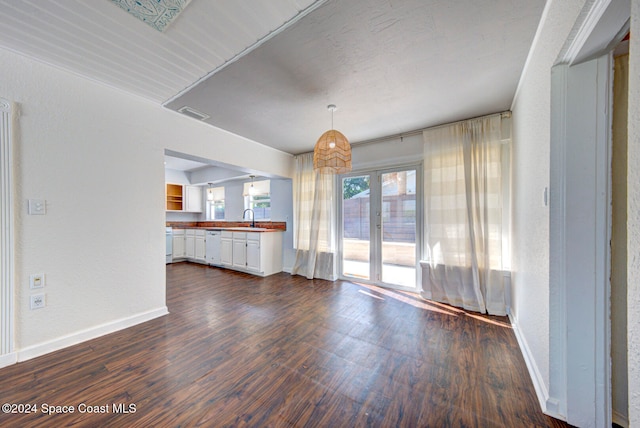 unfurnished living room featuring french doors, dark hardwood / wood-style flooring, and sink