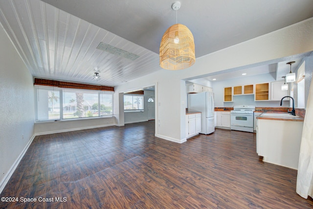 kitchen with hanging light fixtures, white appliances, sink, and dark hardwood / wood-style flooring