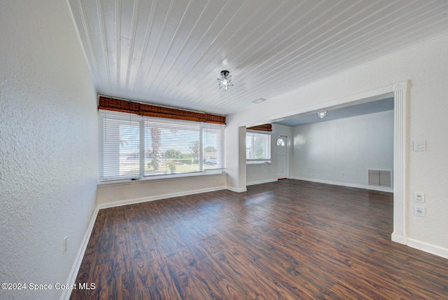 unfurnished living room featuring dark wood-type flooring and wood ceiling