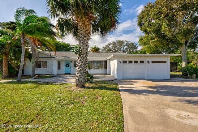 ranch-style home featuring a garage and a front lawn