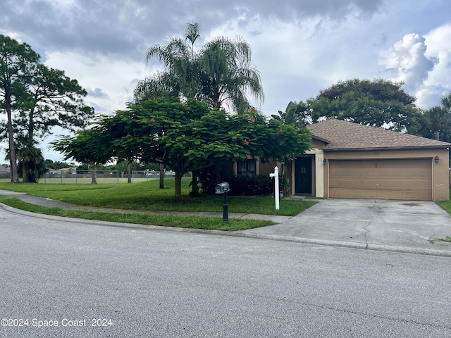 obstructed view of property with a front yard, fence, driveway, roof with shingles, and an attached garage