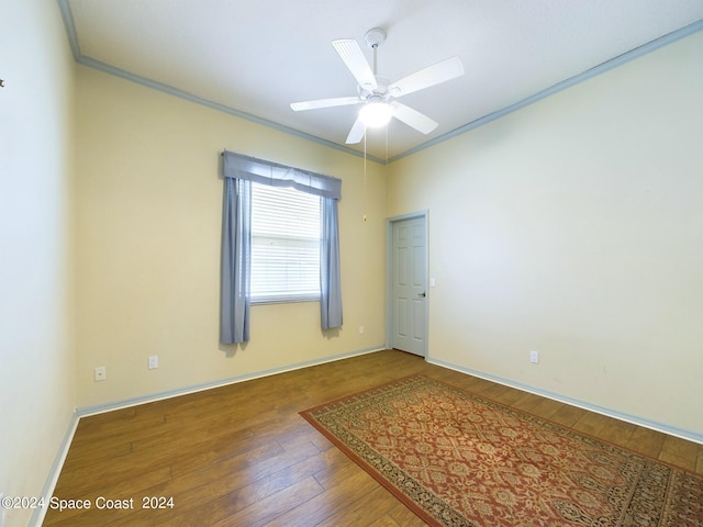 empty room featuring ceiling fan, dark hardwood / wood-style flooring, and crown molding