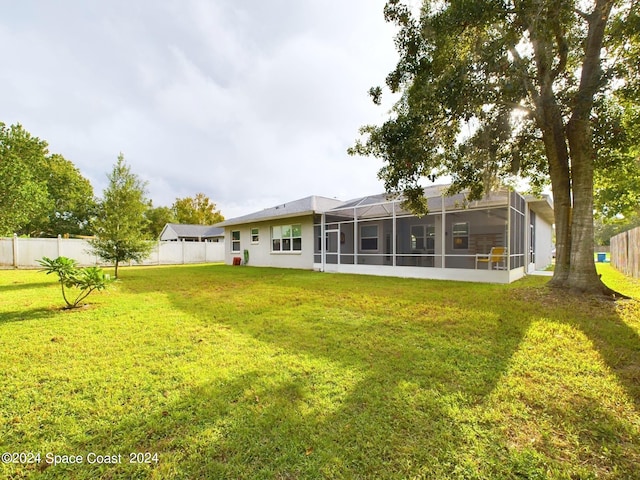 back of property with a yard and a sunroom