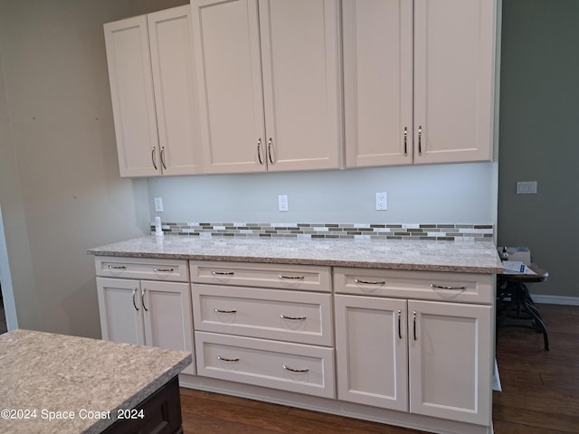 kitchen featuring dark hardwood / wood-style flooring, light stone countertops, and white cabinets