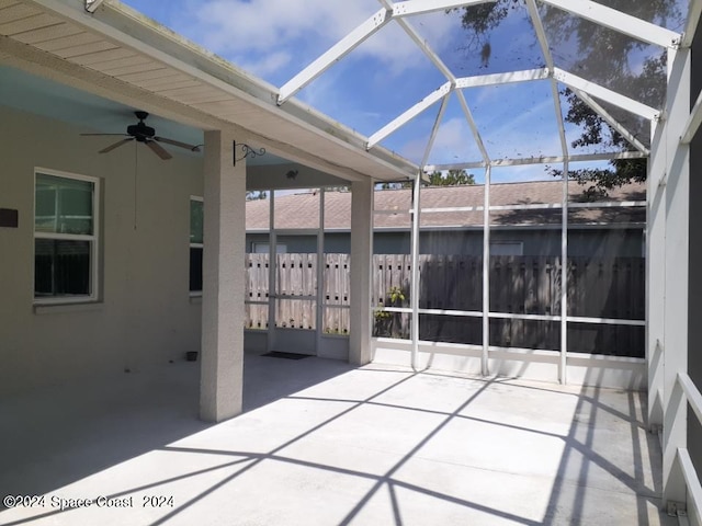 view of patio featuring glass enclosure and ceiling fan