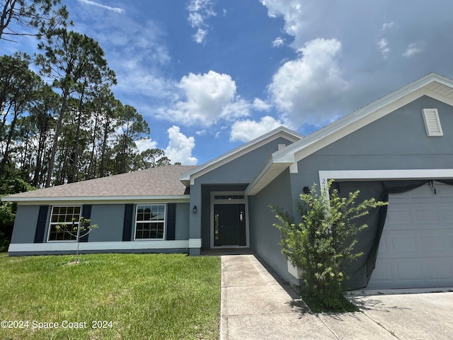 single story home with a garage and a front lawn